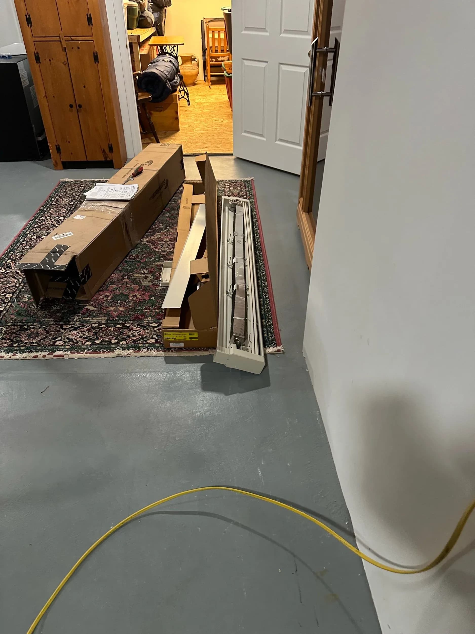 Electric Baseboard Heater Boxes Staged In Basement Doorway