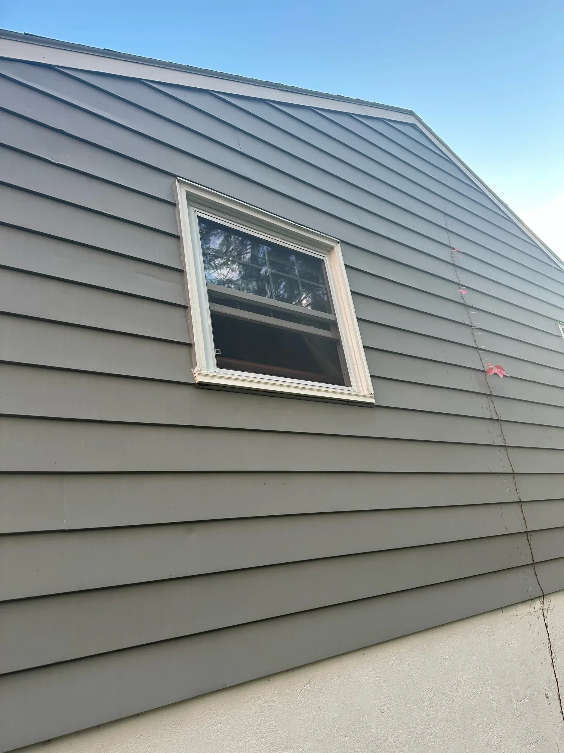 Gray Vinyl Siding Gable Window Trim Closeup