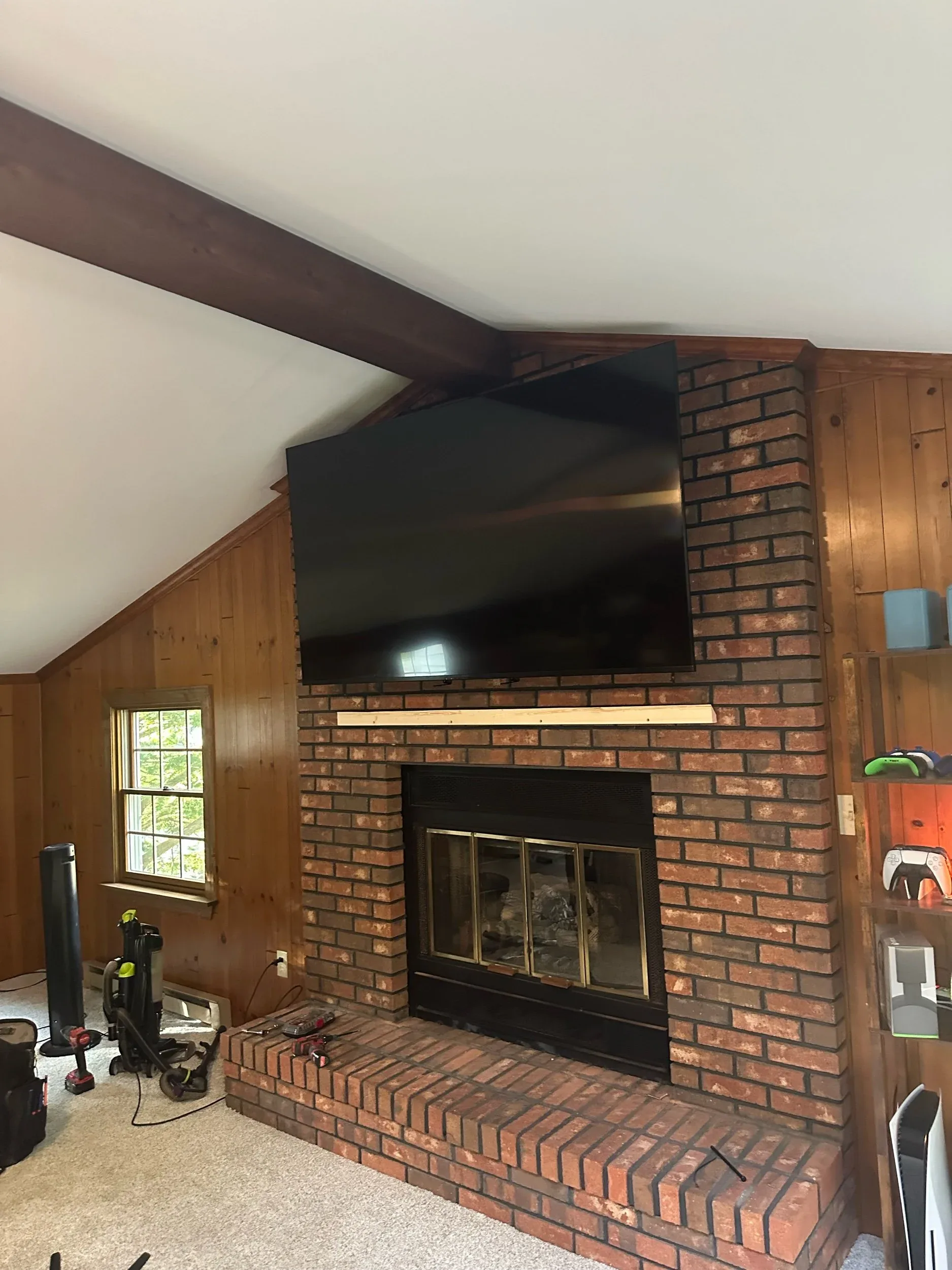 Vaulted Living Room TV Mounted Above Brick Fireplace